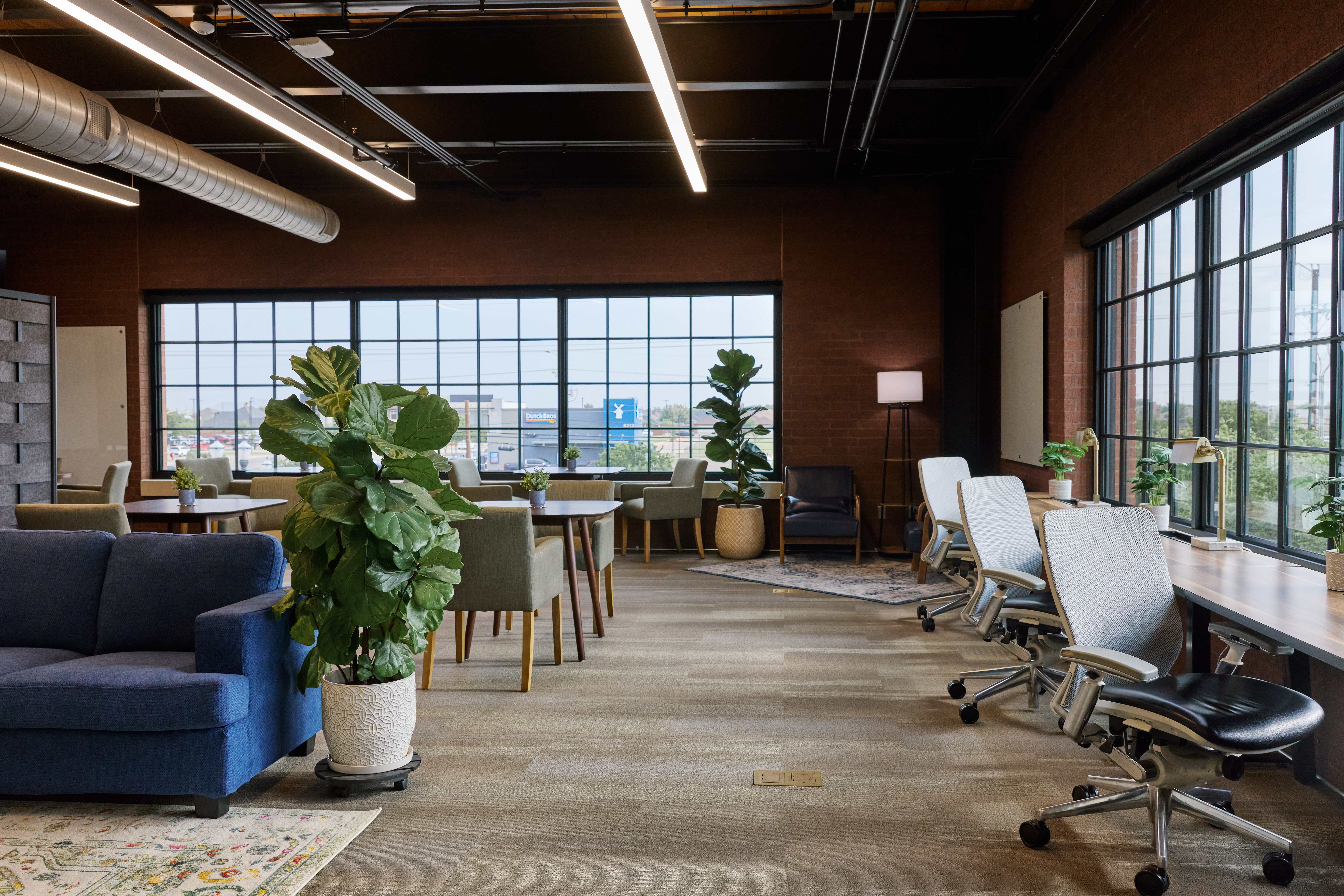 Inside The Station Work Club — open workspace with desks, lounge seating, and floor-to-ceiling windows